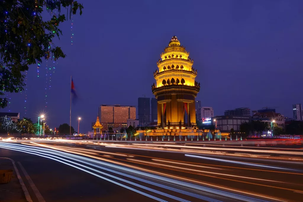 a clock tower lit up at night in phnom penh
