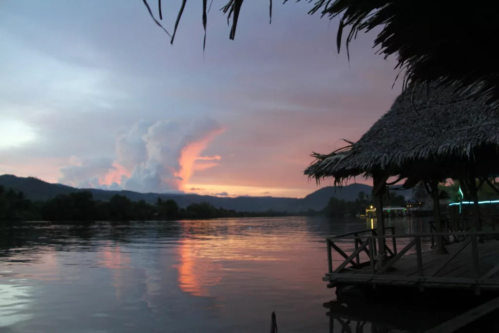 silhouette of palm trees near body of water during sunset Kmapot