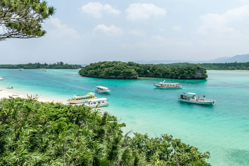 white and blue boat on sea during daytime okinawa