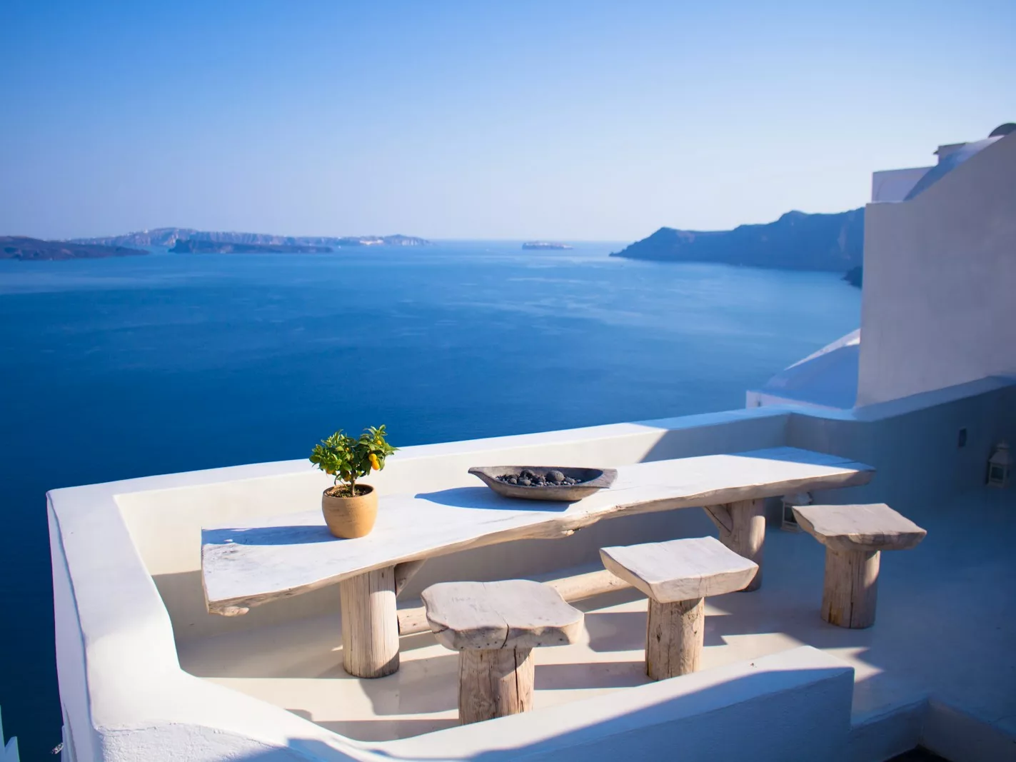 bench and dining table near body of water under calm sky
