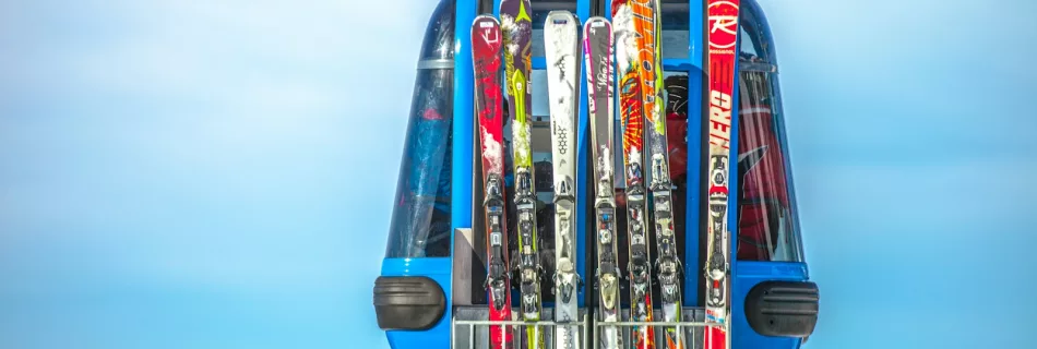 selective focus photography of ski blades on blue cable car